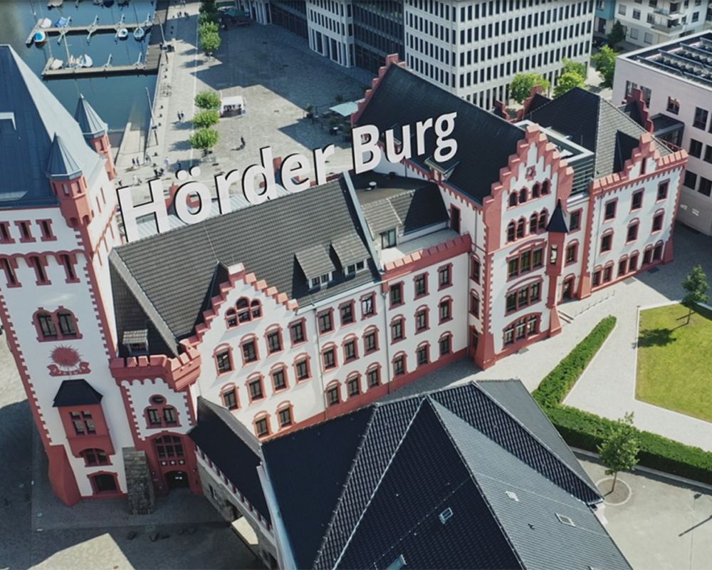 Vogelperspektive auf die Hörder Burg. Auf dem Dach ist der Schriftzug "Hörder Burg" eingebaut.