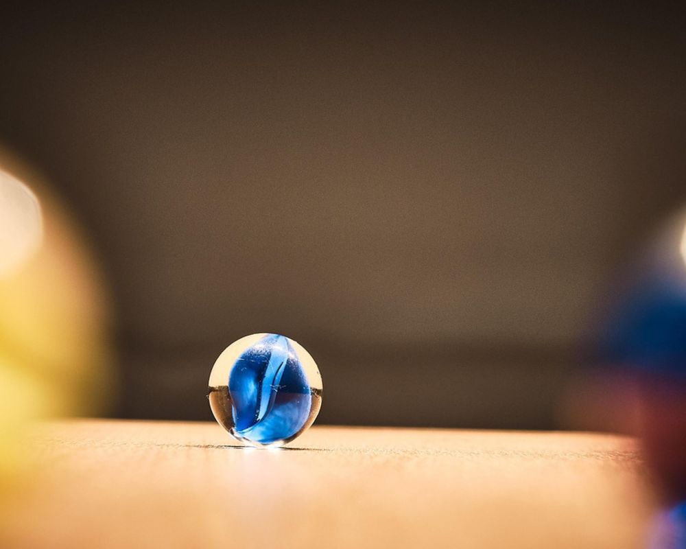 Fokusaufnahme einer Murmel auf einem Holztisch